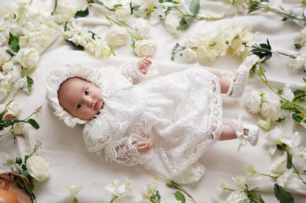 a baby doll laying on a bed of flowers