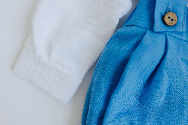 A white shirt and a blue dress with a button are shown in the image.