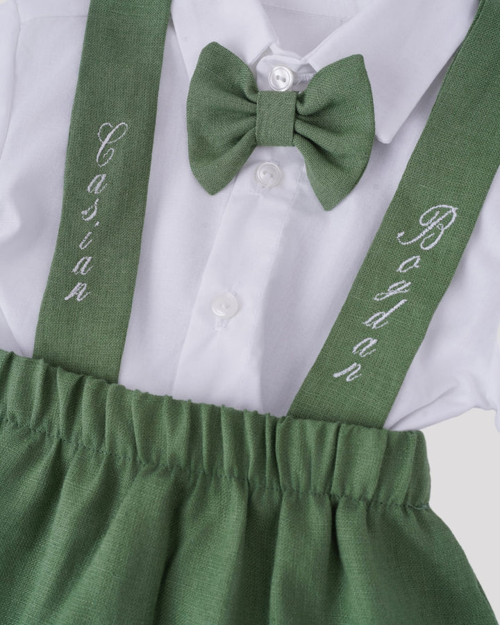 A white shirt with a green bow tie and green suspenders with the name "Boys" printed on them.