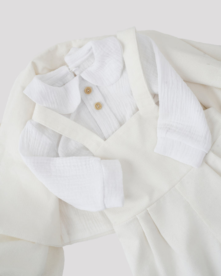 A white dress with a collar and buttons, along with a white shirt, is displayed in the image.