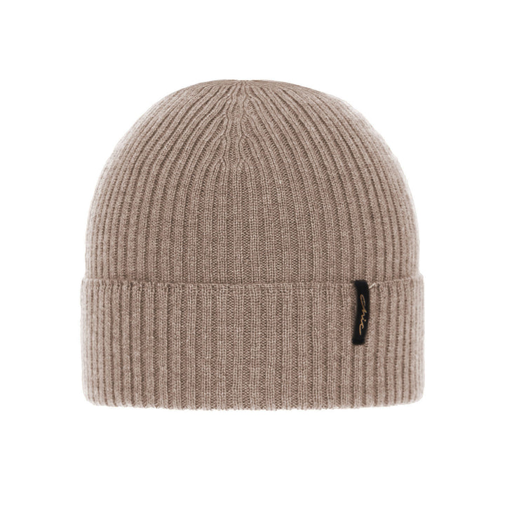A beige, ribbed knit beanie with a small black tag attached to the front.