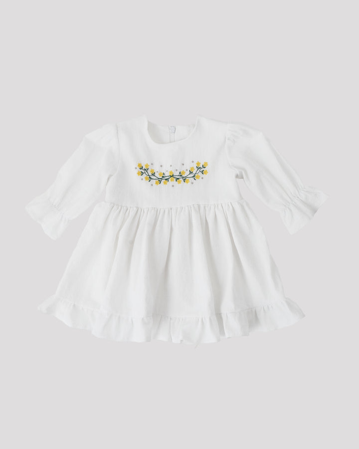 A white dress with a ruffled collar and a floral embroidered design on the front.