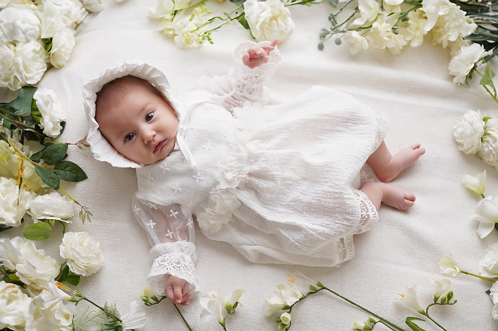 a baby is laying on a bed of flowers
