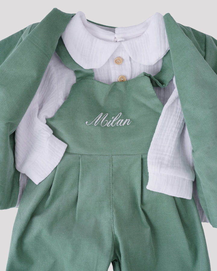 A green jumpsuit with white buttons and a white shirt underneath, with the name "Milan" embroidered on the front.