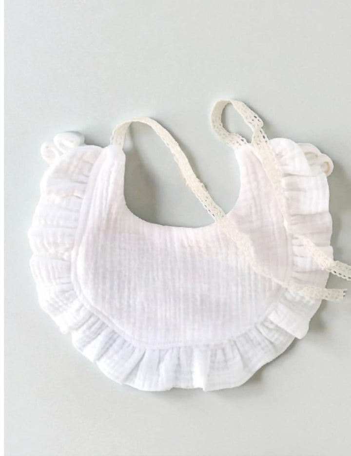 A white ruffled bib with lace trim is shown against a light background.