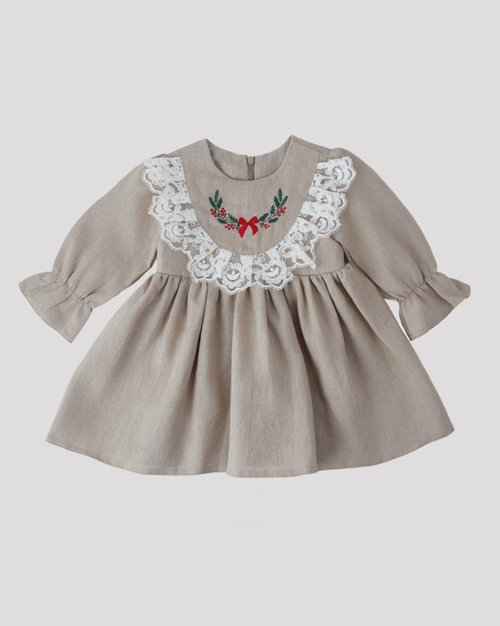 A beige dress with lace trim and a red bow on the front.