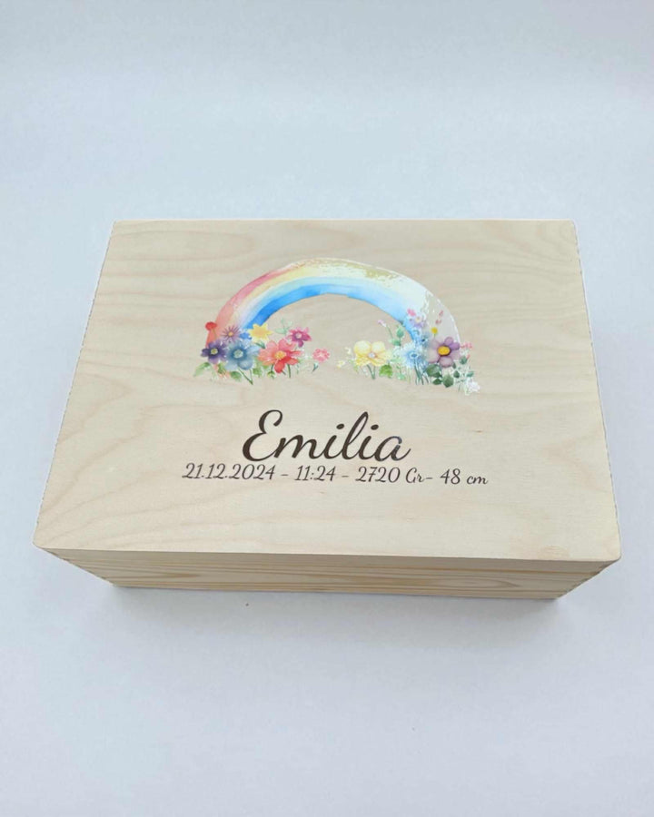 A wooden box with a colorful rainbow graphic and the name "Emilia" printed on it.