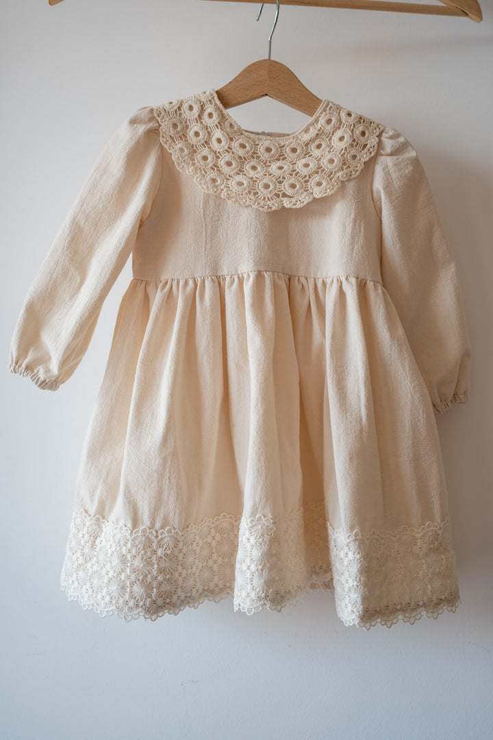 a baby dress hanging on a clothes rack