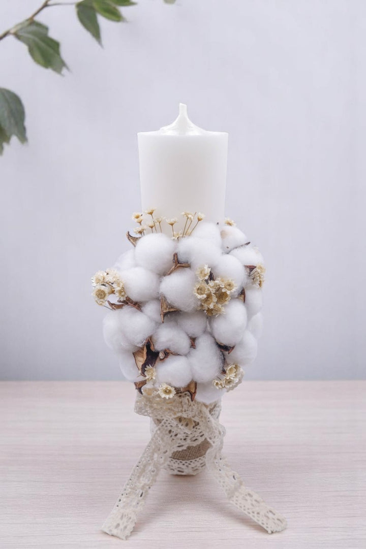 a white candle with a bunch of cotton on top of it