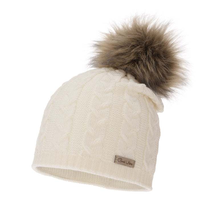 A white knitted beanie with a fluffy brown pom pom on top, featuring a small label on the front.
