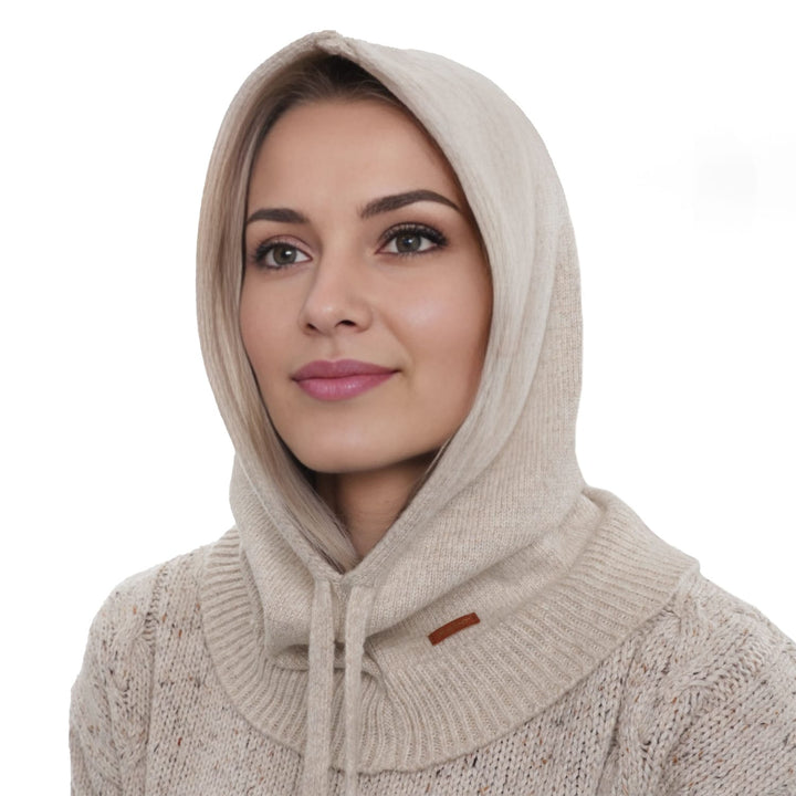 A woman wearing a beige hooded sweater and looking off to the side with a neutral expression.