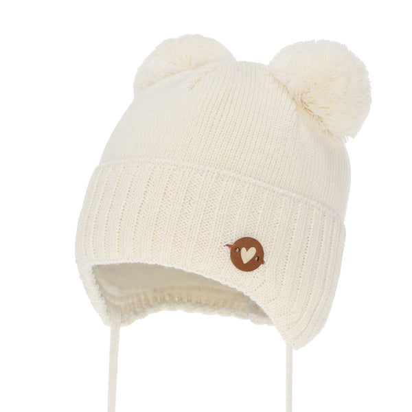 A white knit beanie with pom poms on the ears and a small brown heart-shaped button on the front.