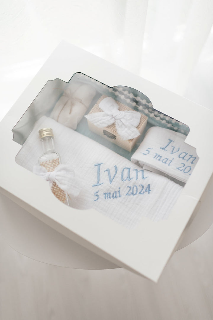 A white gift box containing various items, including a small bottle, a white cloth, and a white bow. The text on the gift box indicates that it is a gift for someone named Ivan, and it was given on May 5, 2014.