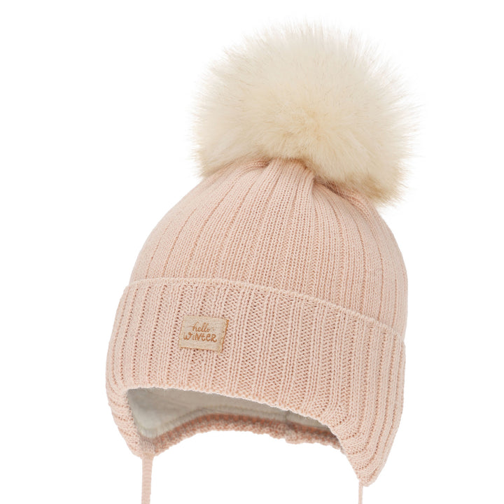 A pink knit beanie with a fluffy white pom pom on top, featuring a small label on the front.
