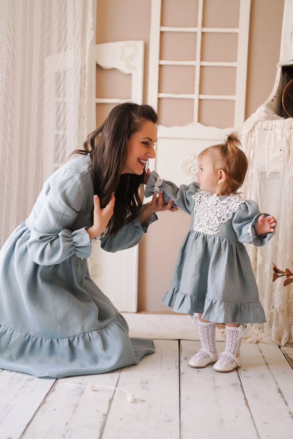 a woman kneeling down next to a little girl
