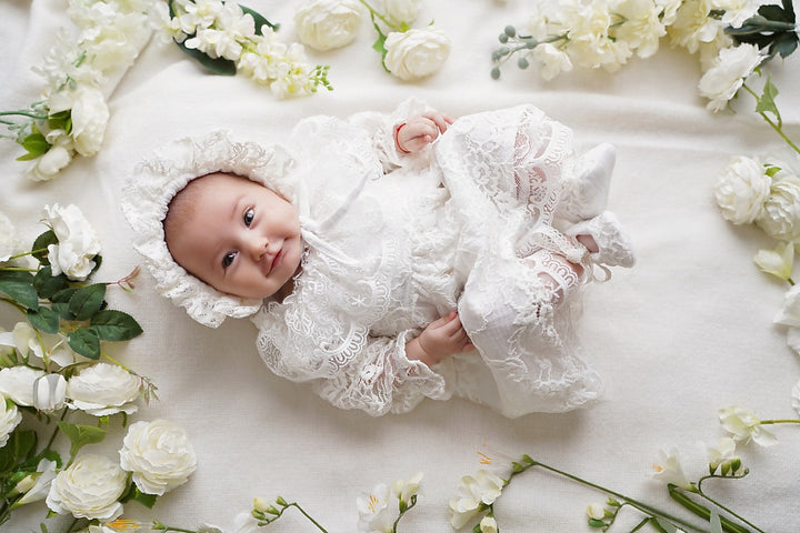 a baby laying on a bed of white flowers