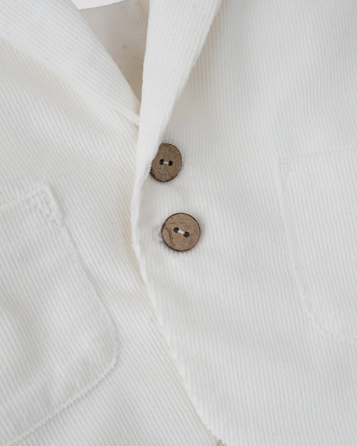 a close-up view of a white jacket with two buttons visible.