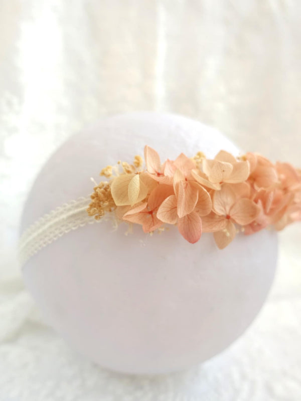 A white round object with a delicate floral arrangement of peach and white flowers on it.