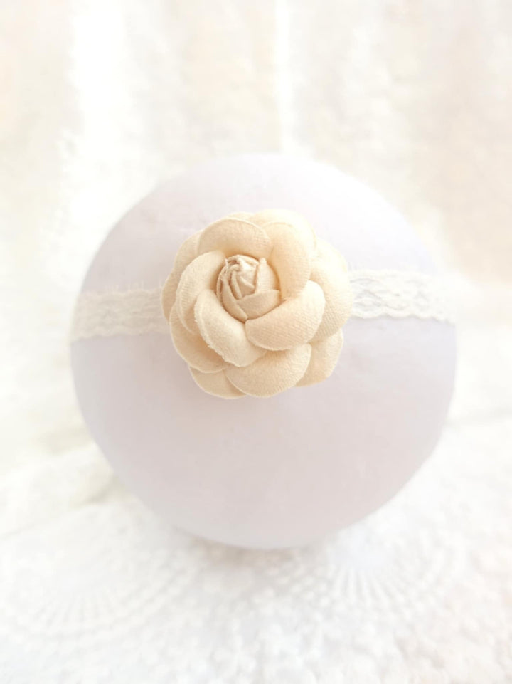A white ball with a delicate white flower on top, placed on a white surface.
