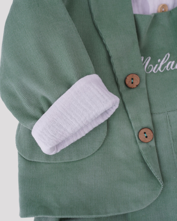 A close-up view of a green corduroy jacket with a white sleeve and buttons.
