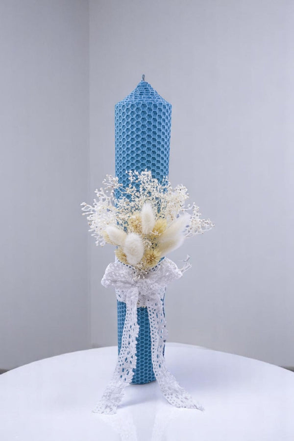 a blue vase with white flowers on a table