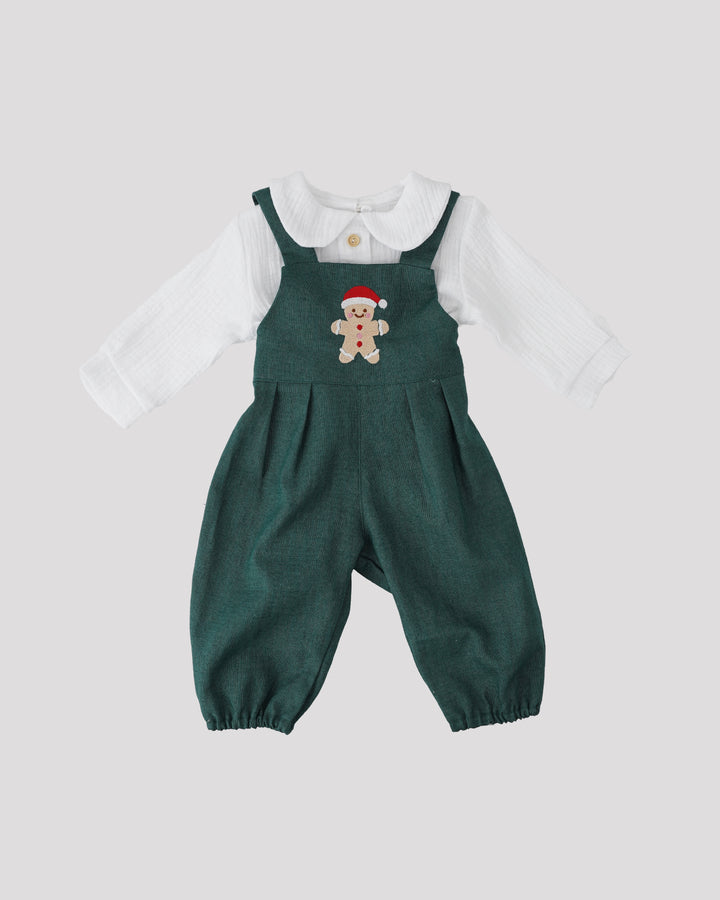 A green jumpsuit with a white collar and a red Santa hat on the front, along with a white long-sleeved shirt.