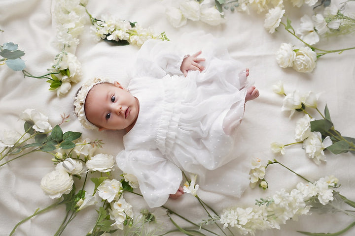 a baby laying on a bed of flowers