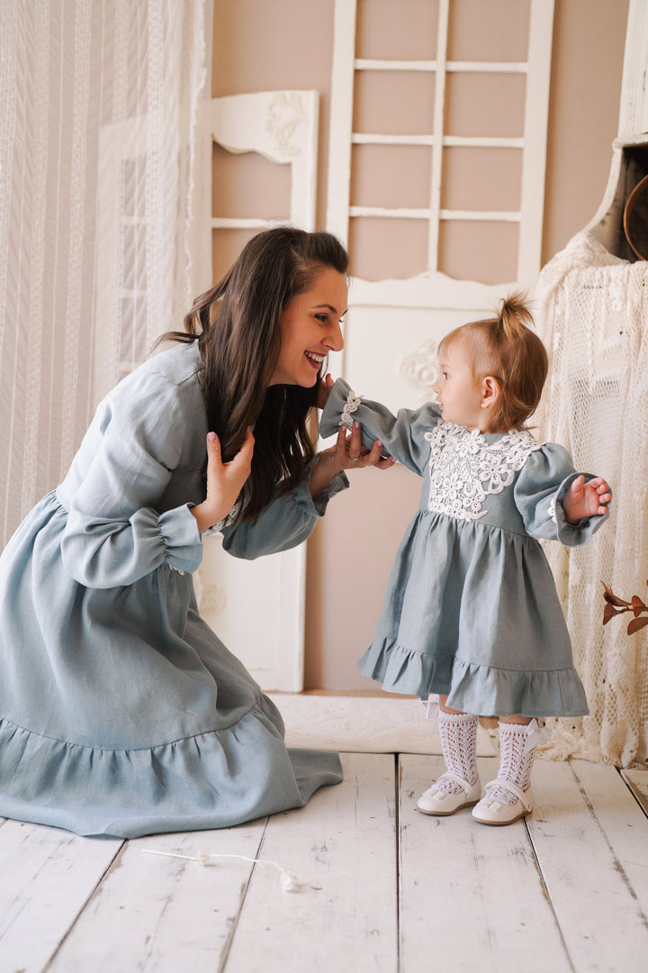 a woman kneeling down next to a little girl