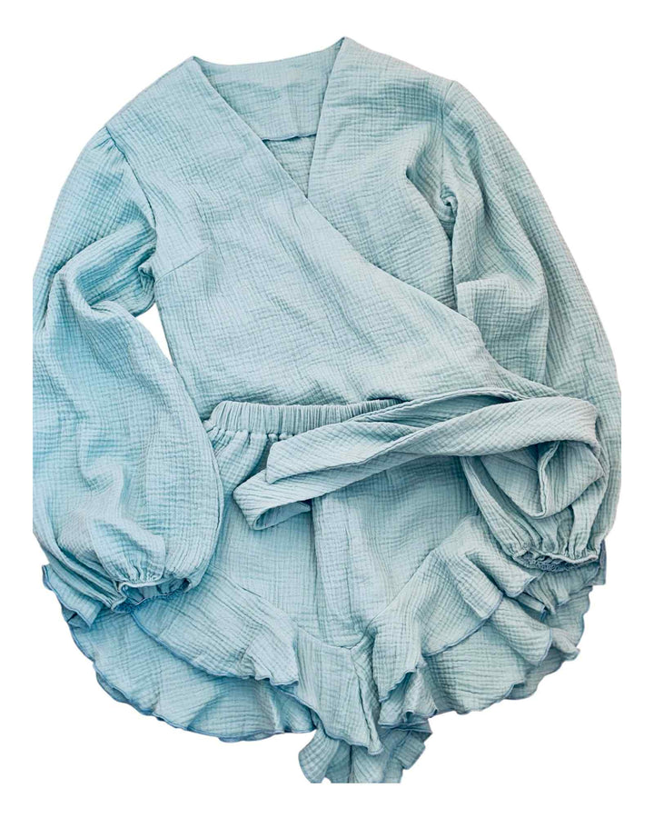 A light blue, long-sleeved dress with a wrap-style neckline and a ruffled skirt.