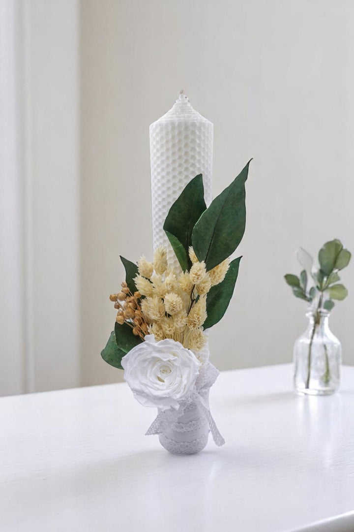 a vase with flowers and a candle on a table