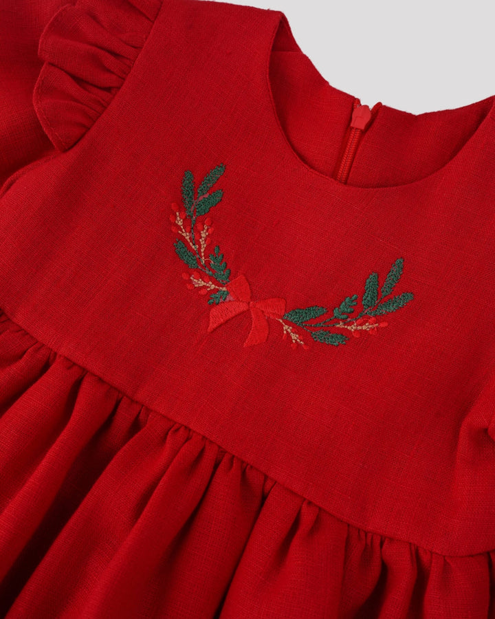 A red dress with a ruffled collar and a decorative leaf pattern on the front.