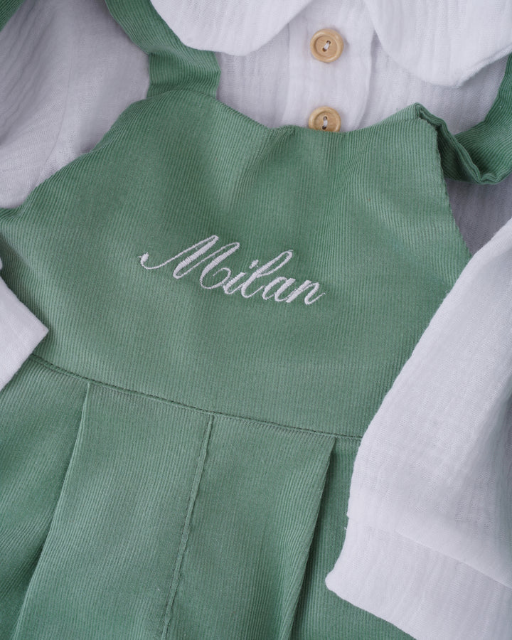 A green dress with the name "Milan" embroidered on it.