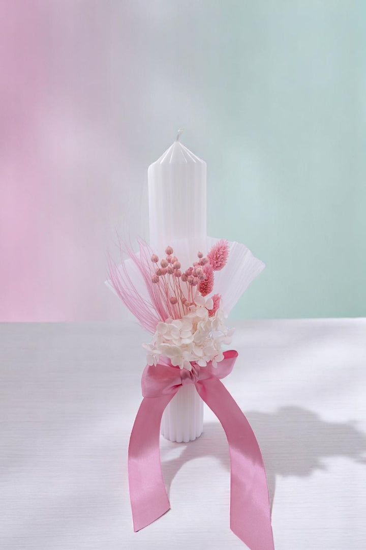 a white vase with a pink ribbon around it