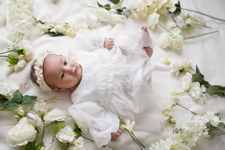 a baby laying on a bed of flowers