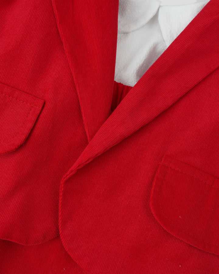 A close-up view of a red jacket with a white shirt underneath, showcasing the fabric and details of the jacket and shirt.