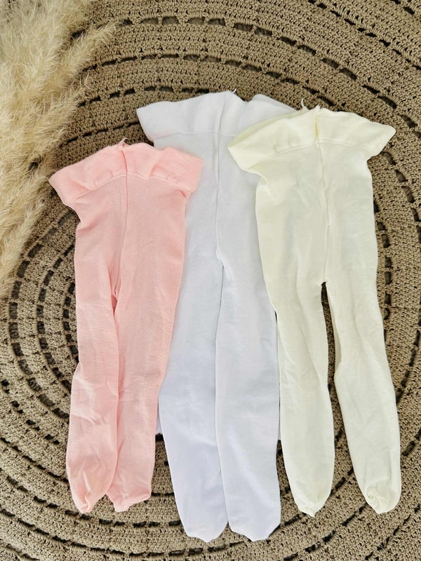 Three pairs of tights in different colors - pink, white, and yellow - laid out on a circular patterned surface.