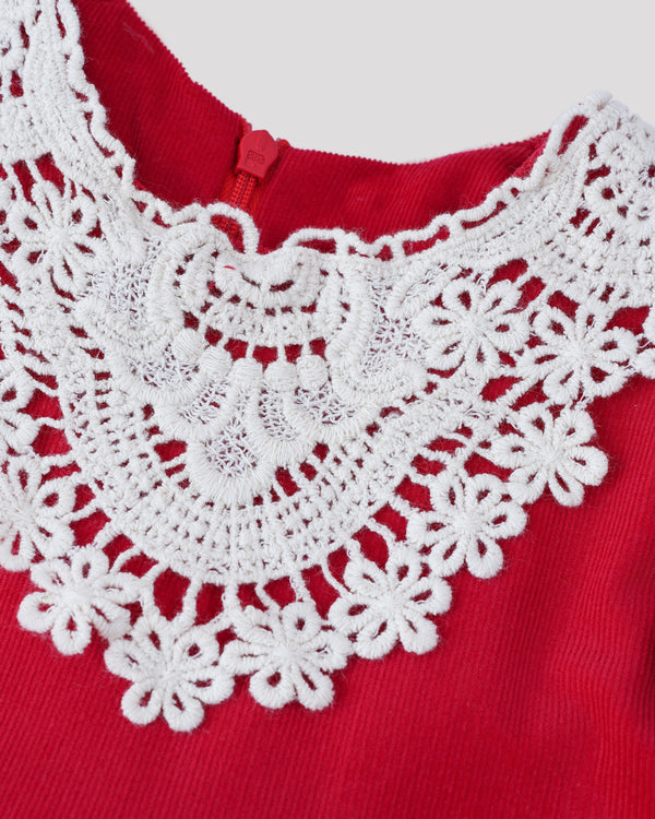 A close-up view of a red fabric with a delicate white lace trim, creating an intricate and elegant design.