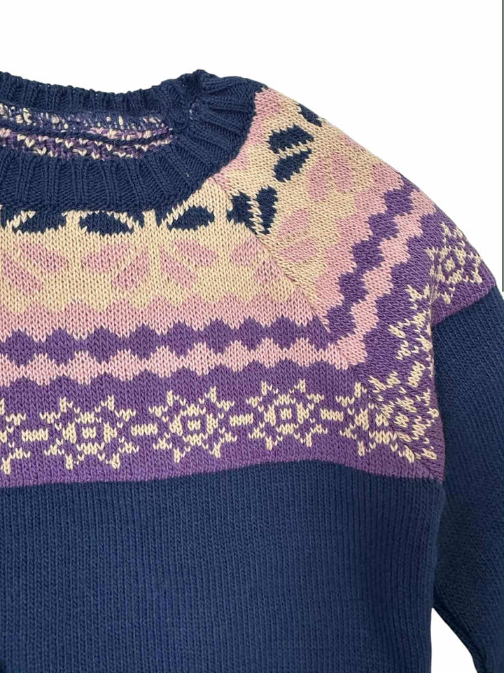 A close-up view of a knitted sweater with a colorful, patterned design.