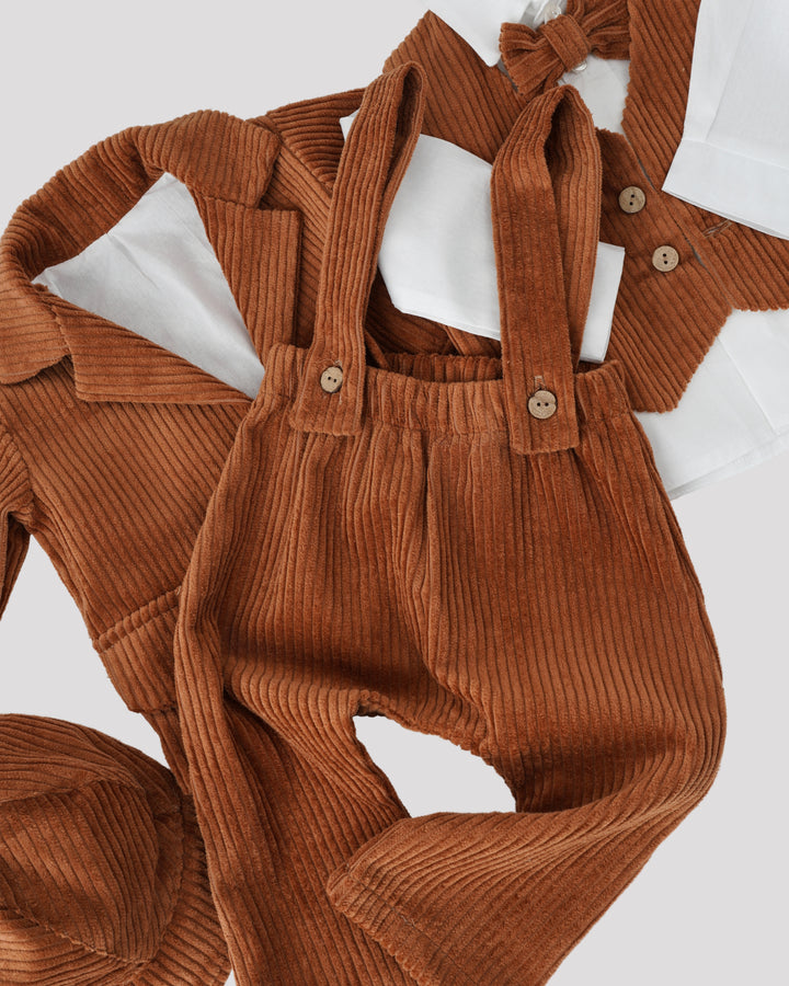 a collection of clothing items, including a brown jacket, a white shirt, and a pair of brown pants with suspenders.