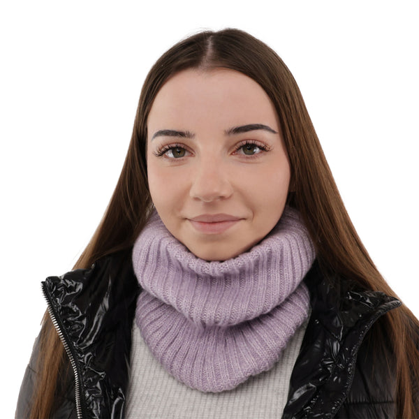 A young woman with long brown hair and a purple scarf is smiling at the camera.
