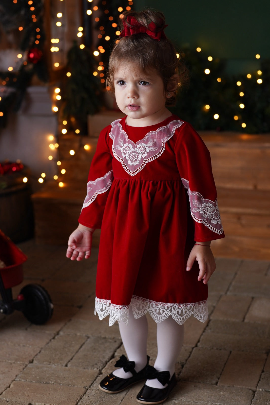 a little girl in a red dress and black shoes